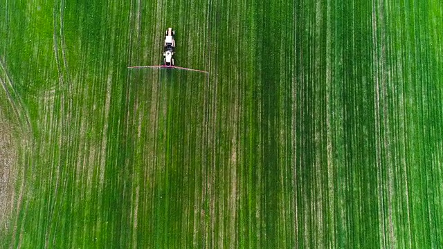 农业。农用拖拉机喷洒农田俯视图。视频素材