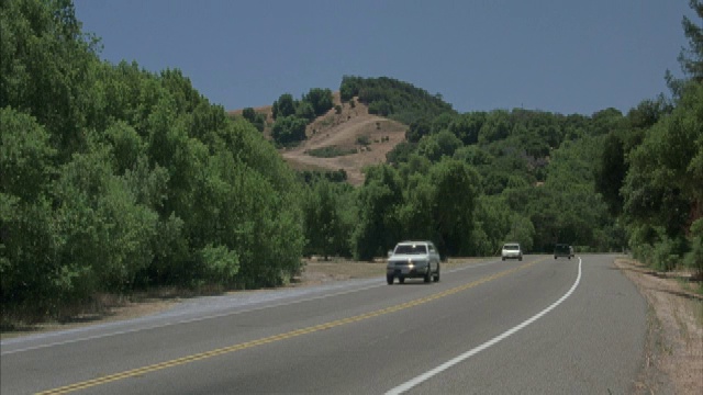 在双车道山区公路上双向行驶的车辆。视频素材