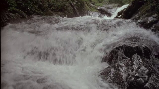 瀑布在岩石上飞溅。视频素材