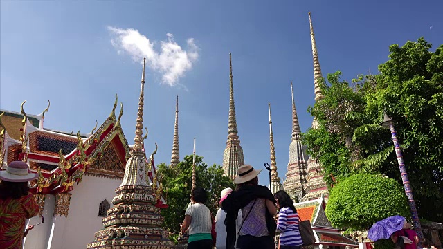 游客们在泰国曼谷的卧佛寺欣赏许多佛塔视频素材