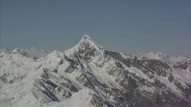 一架直升机飞过积雪的山口。视频素材