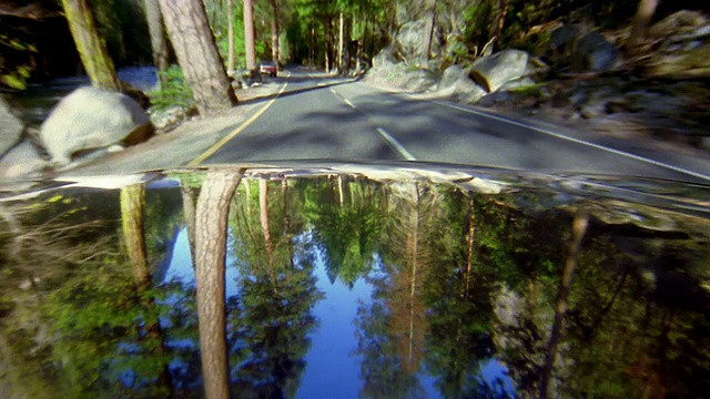 汽车的观点，沿河行驶的道路通过约塞米蒂国家公园/天空和树木反映在hood视频素材