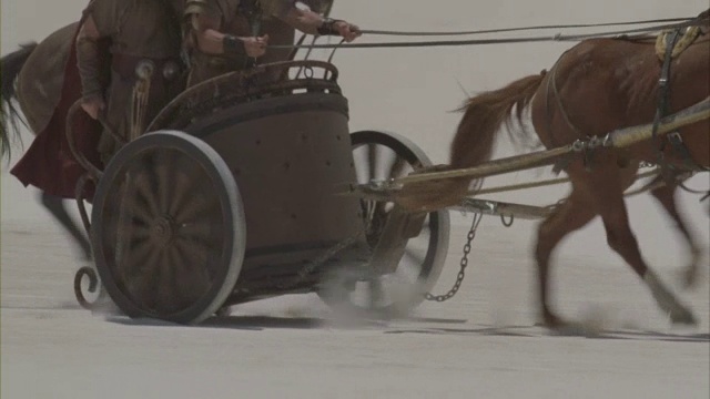 罗马士兵骑着马和战车在白雪皑皑的沙漠中冲锋。视频素材