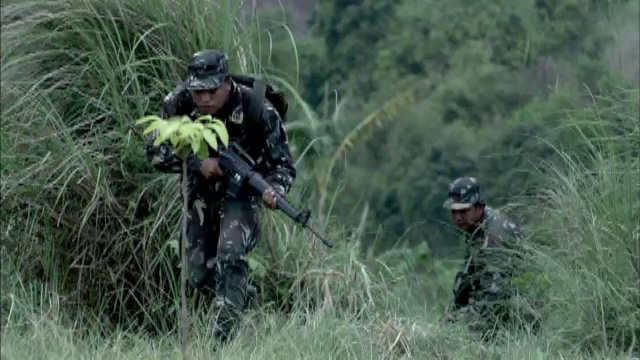 当爆炸在他们周围响起时，士兵们跑过一片草地。视频素材