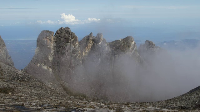 在婆罗洲基纳巴卢山的岩石山峰上，流逝的云滚滚而过视频素材