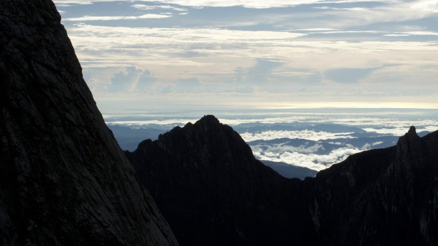 在婆罗洲基纳巴卢山的岩石山峰上，时间推移的云翻腾视频素材