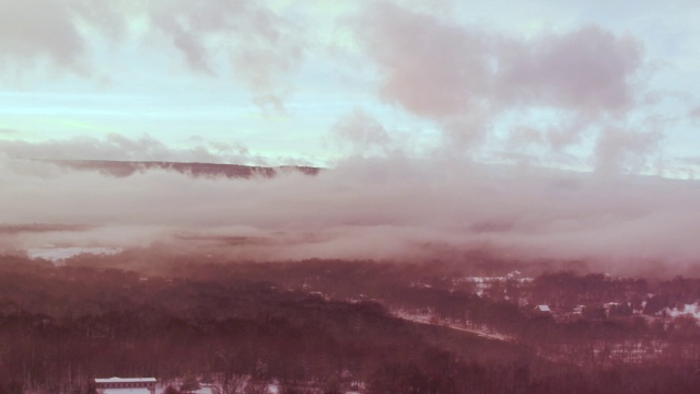 空中飞过树梢，白雪覆盖的风景，夕阳视频素材