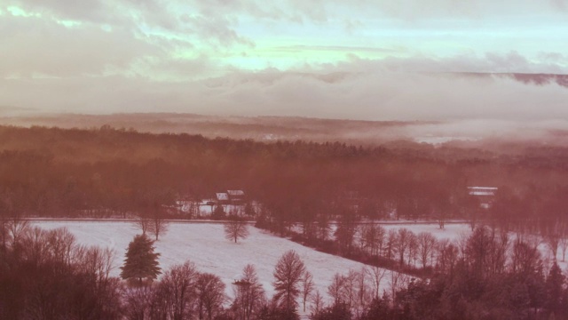 空中飞过树梢，白雪覆盖的风景，夕阳视频素材