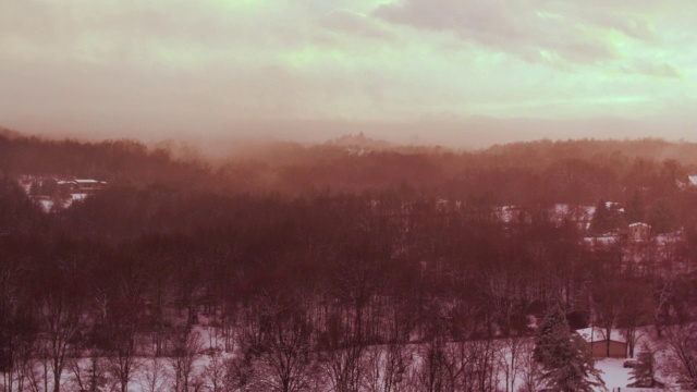 空中飞过树梢，白雪覆盖的风景，夕阳视频素材