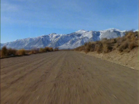 汽车的观点在土路与雪山的背景视频素材