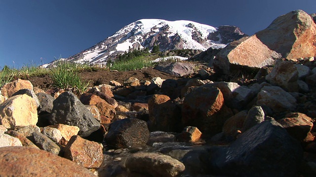 美国华盛顿州雷尼尔山国家公园，以积雪覆盖的雷尼尔山为背景的山溪视频素材