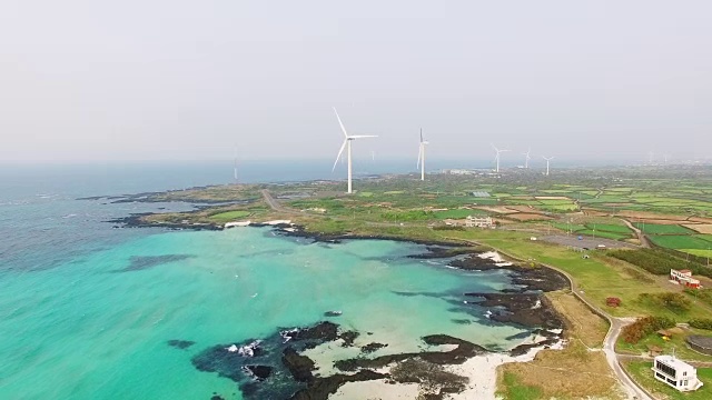 鸟瞰图的金宁Seonsegi海滩(著名的绳索钓鱼从岩石)与风力发电机视频素材