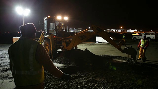 南非开普敦，挖掘机和工人们用铲子在建筑工地上挖掘旧的道路视频素材