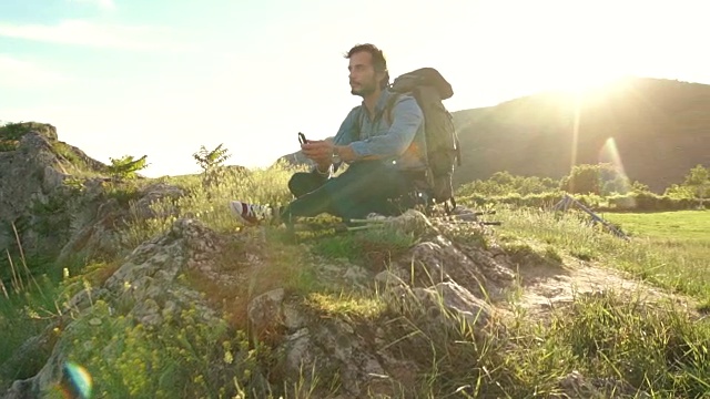 徒步旅行者坐在草地上视频素材