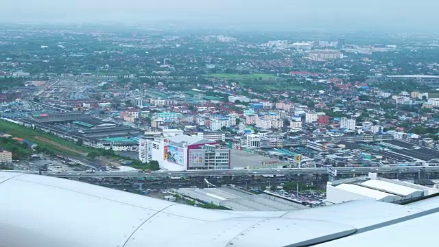 从飞机机舱窗口俯瞰城市上空的鸟瞰图。视频素材