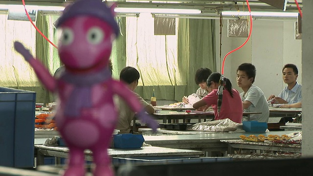 MS People working in toy factory/ RACK FOCUS Plastic toy in foreground/ RACK FOCUS Workers in background/中国东莞视频素材