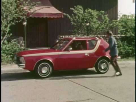 蒙太奇WS ZO夫妇跑出大楼，进入红色1973 AMC Gremlin/ WS汽车开车离开，后面是刚结婚的标志/美国视频素材