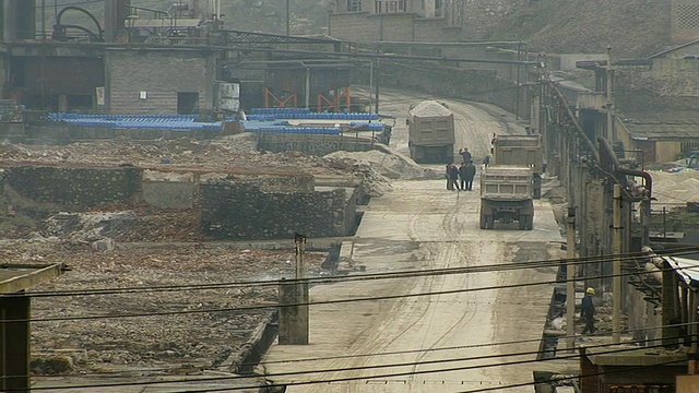 磷矿道路上的卡车/ PAN WS从工业建筑顶部冒出的烟雾/中国贵阳视频素材