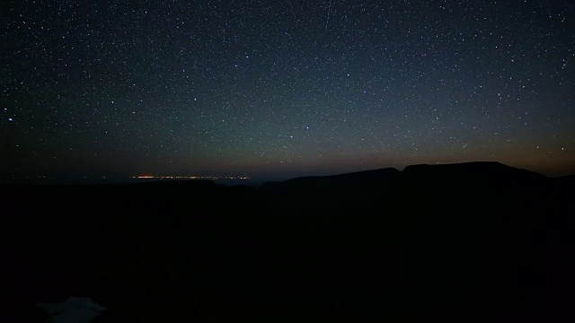 黑暗的夜空和白天到晚上的日出，金格峡谷山顶与灯光伯恩斯市在远处的马勒尔国家野生动物保护区视频素材