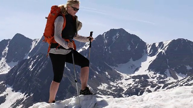 女性徒步者攀登雪山的山脊顶部景观视频素材