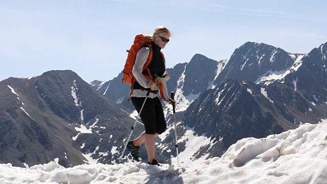 女性徒步者攀登雪山的山脊顶部景观视频素材