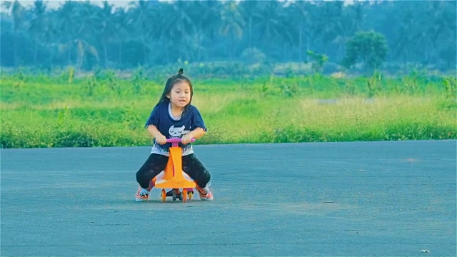 亚洲小女孩在乡下玩秋千车视频素材