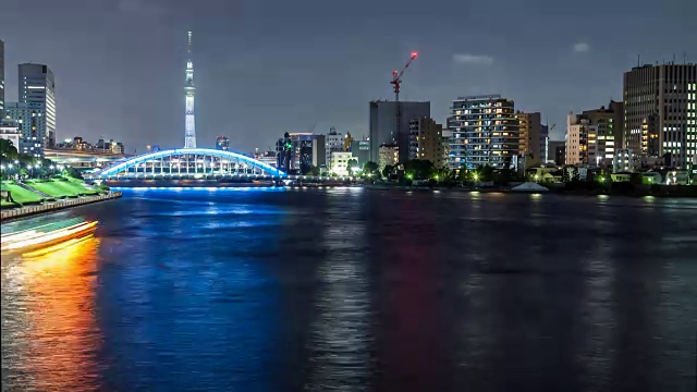 4K时间间隔的东京城市夜景，许多房屋船照明和永泰桥，东京住田河上的天空树在筑岛地区，中央区，东京，日本。视频素材