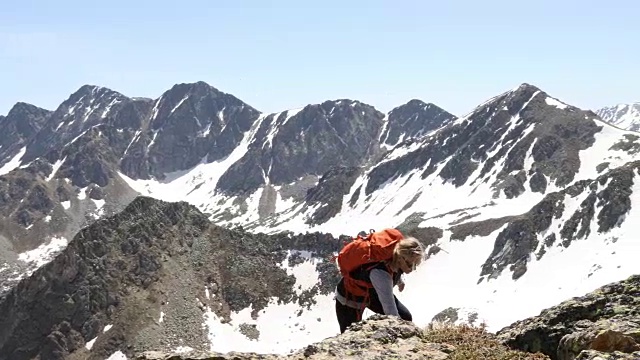 女性徒步者攀登雪山的山脊顶部景观视频素材