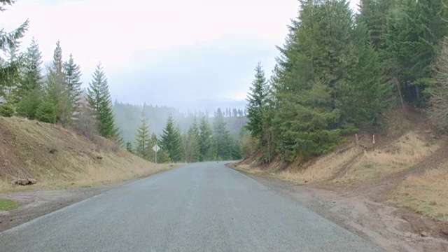 在俄勒冈州的春天，开车沿着空旷的公路拍摄湿雨瀑布山森林视频素材