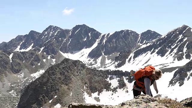 女性徒步者攀登雪山的山脊顶部景观视频素材