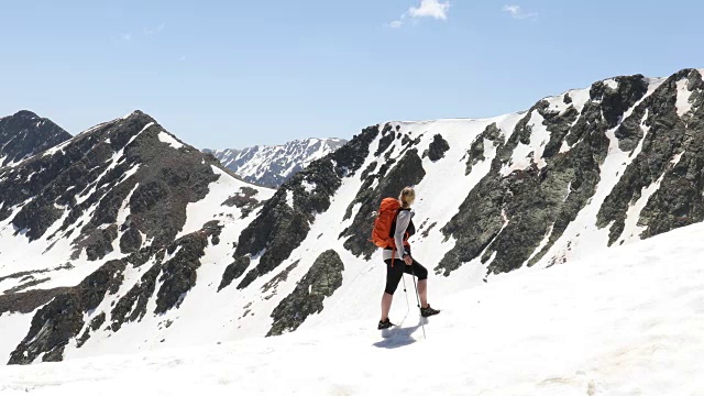 女性徒步者攀登雪山的山脊顶部景观视频素材