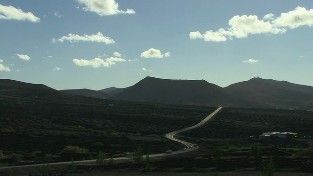 T/L, WS, HA，道路通过火山景观，葡萄园，山的背景，La Geria，兰萨罗特，加那利群岛，西班牙视频素材