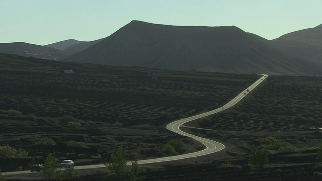 WS, HA，通过火山景观的道路，葡萄园，山脉的背景，La Geria，兰萨罗特，加那利群岛，西班牙视频素材