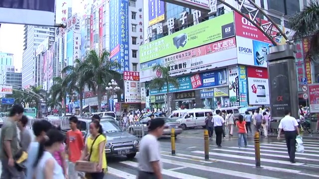 覆盖着广告的WS银行大楼/ ZO繁忙十字路口的交通和人群/中国深圳视频素材