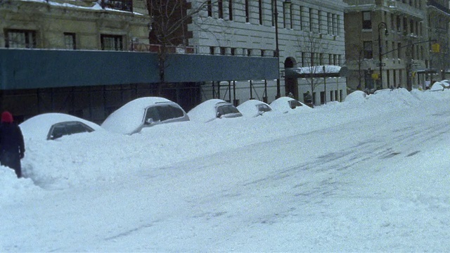 2003年，暴风雪期间，一辆中型出租车驶过公园大道上的大楼视频素材