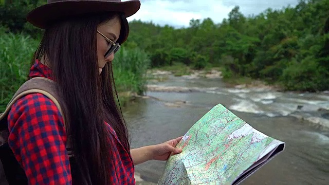 年轻女性在冒险旅行中看地图。视频素材