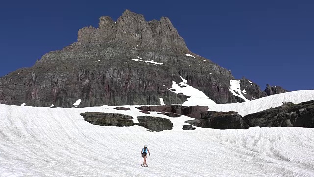 一名妇女在蒙大拿州的冰川国家公园洛根山口雪原上徒步旅行视频素材