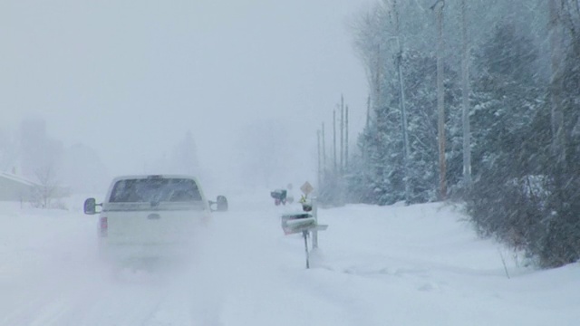 威斯康辛州霍顿维尔，一辆皮卡行驶在暴风雪中的乡村公路上视频素材