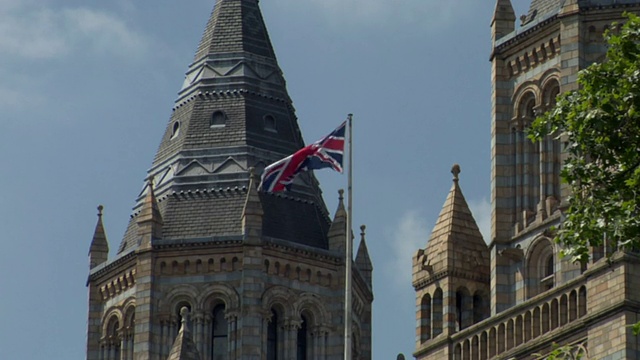 英国伦敦，英国国旗，背景为自然历史博物馆塔视频素材