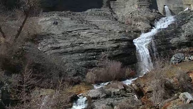 缓慢上升，仰望瀑布从岩石山坡流下视频素材