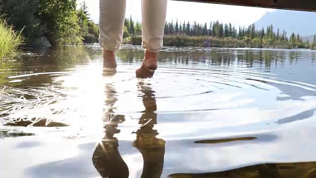 女人的双腿悬在山湖上方的桥上视频素材