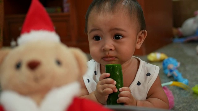 宝宝吃黄瓜，圣诞熊在前景视频素材