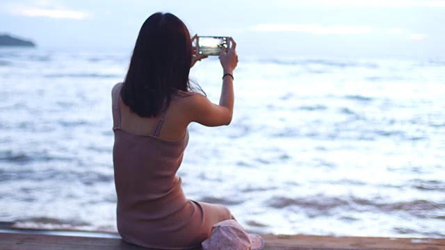 年轻女子拍摄的海景视频素材