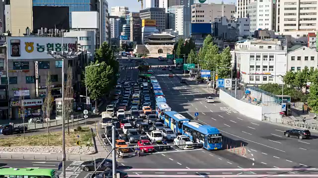 在中古的首尔站和仙叶门(韩国国宝1号)附近的十字路口上行驶的交通景象视频素材