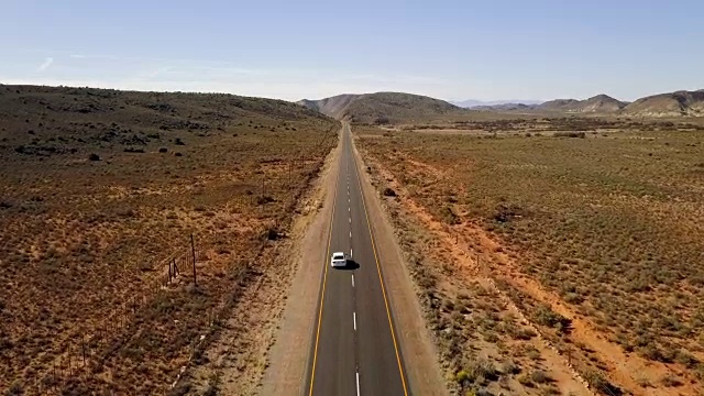 汽车在荒凉的道路上行驶的空中风景视频素材