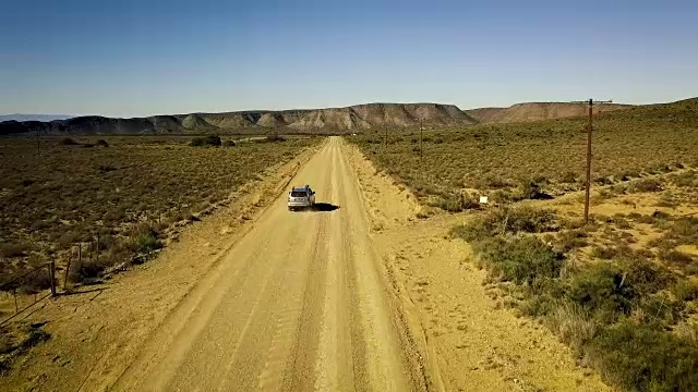 汽车在荒凉的道路上行驶的空中风景视频素材