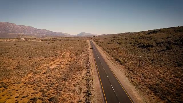 汽车在荒凉的道路上行驶的空中风景视频素材