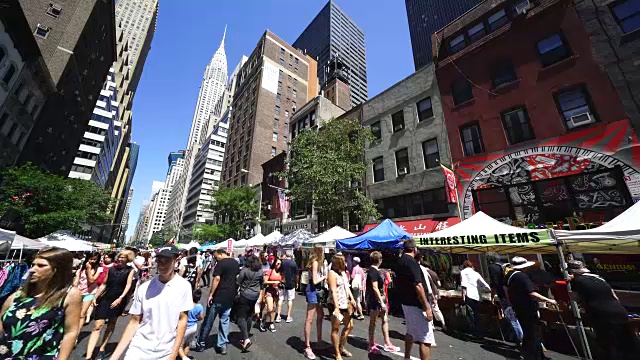 7月30日，在纽约曼哈顿中城的列克星敦大道，街头集市开幕。人们走在列克星敦大街上的许多沿街商店中。后面可以看到克莱斯勒大厦和其他摩天大楼。视频素材