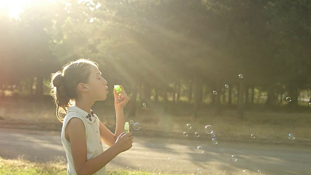 小女孩用慢镜头吹肥皂泡视频素材