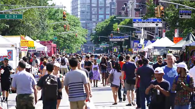 街头集市于2017年7月16日在纽约曼哈顿东村第二大道开幕。人们沿着第二大道走在许多沿街商店中。视频素材